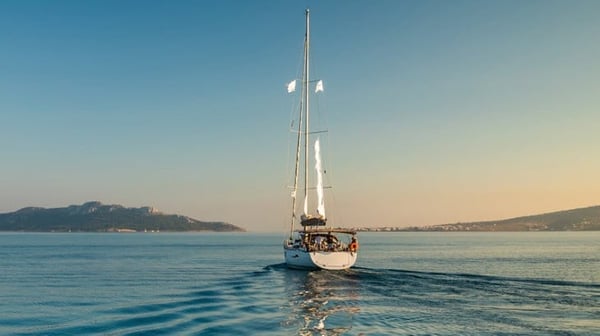 Boat sailing across water with mountains ahead