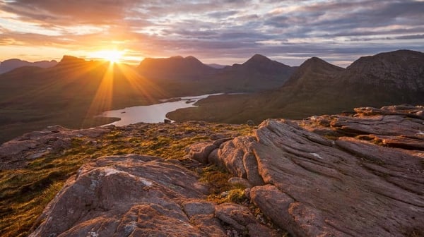 Sunset over rocky landscape and lake