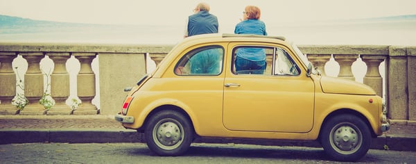 Two people standing by a car admiring the Naples bay