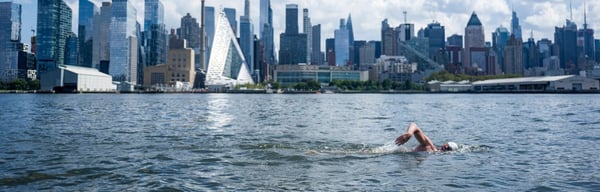 Someone swimming in front of skyscrapers