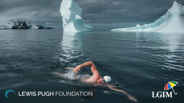 Lewis Pugh swimming in the sea past icebergs